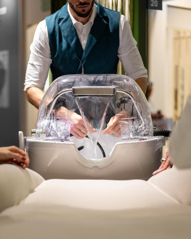 Hairdressing and spa equipment detail: hair treatment bed with cascading water and steam.